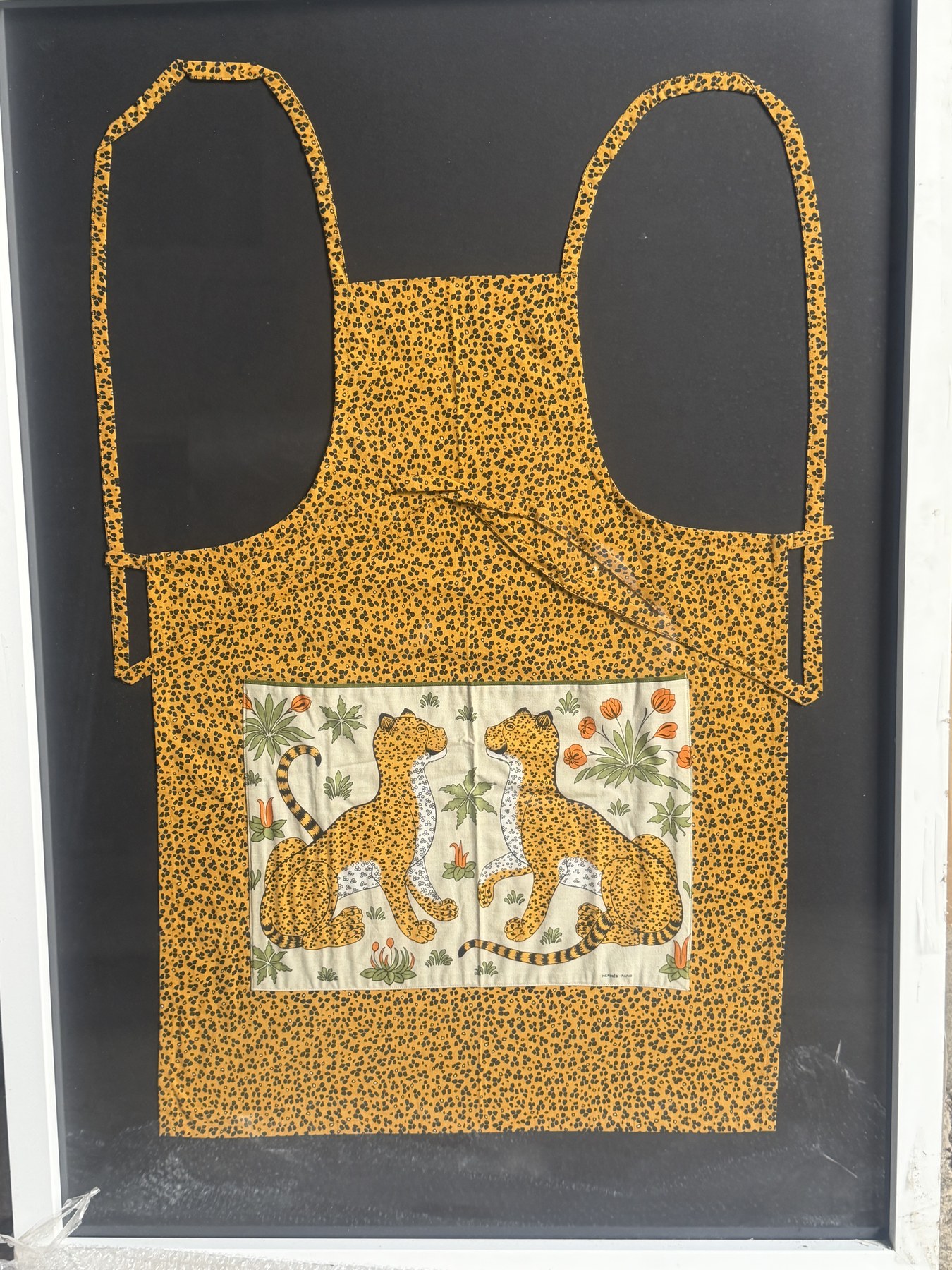 Textile jaune à motifs tachetés, orné de deux félins et de fleurs, présenté dans un cadre sombre