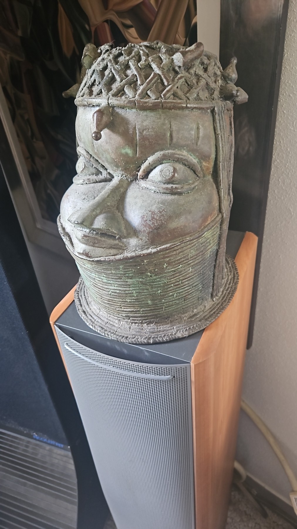 Sculpture cylindrique à patine verte représentant un visage aux yeux expressifs