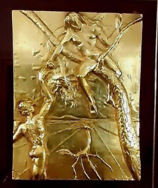 Relief doré montrant un cavalier, un animal et des branches stylisées