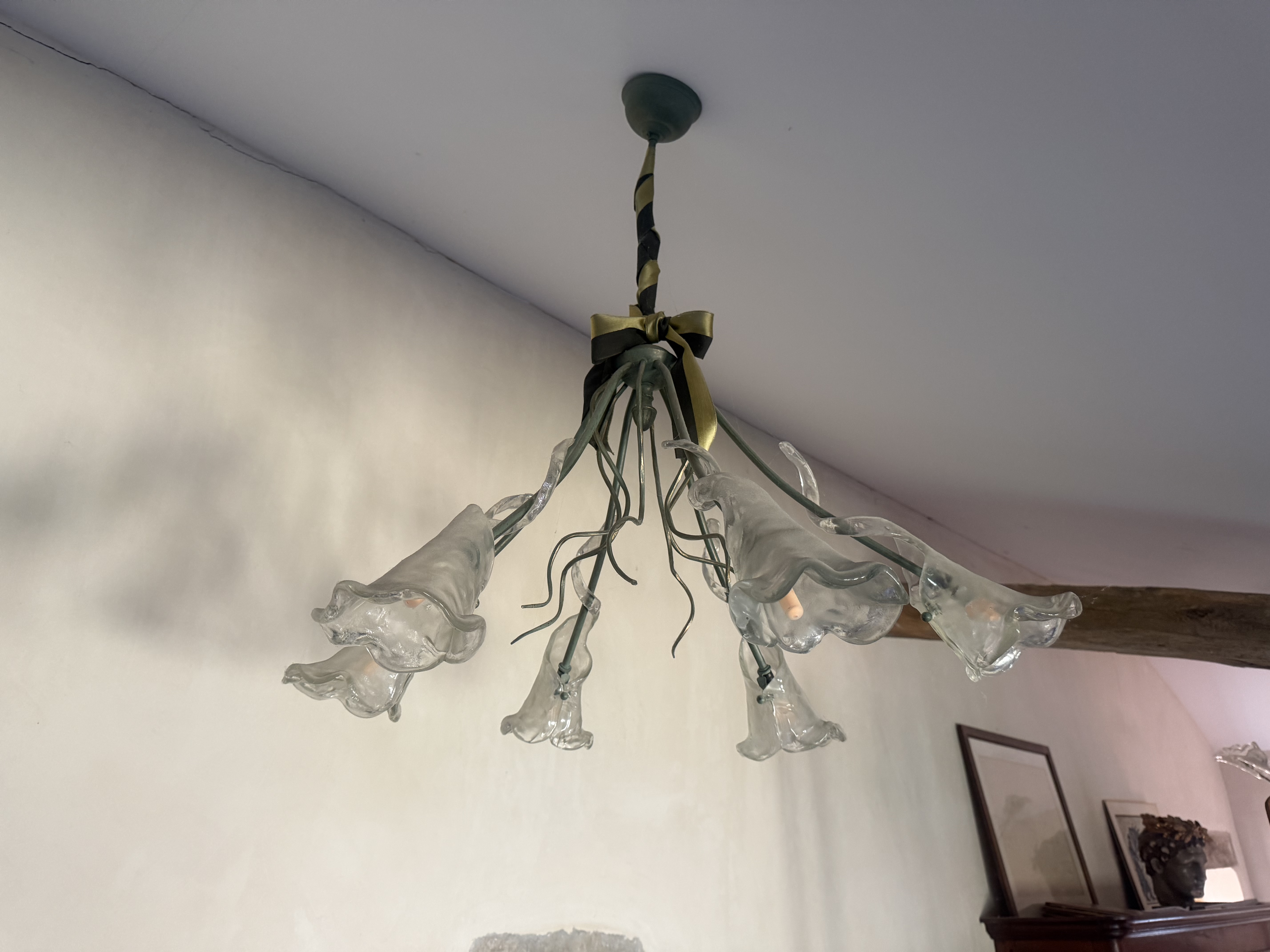 Lustre aux branches sombres terminé par des corolles de verre translucide