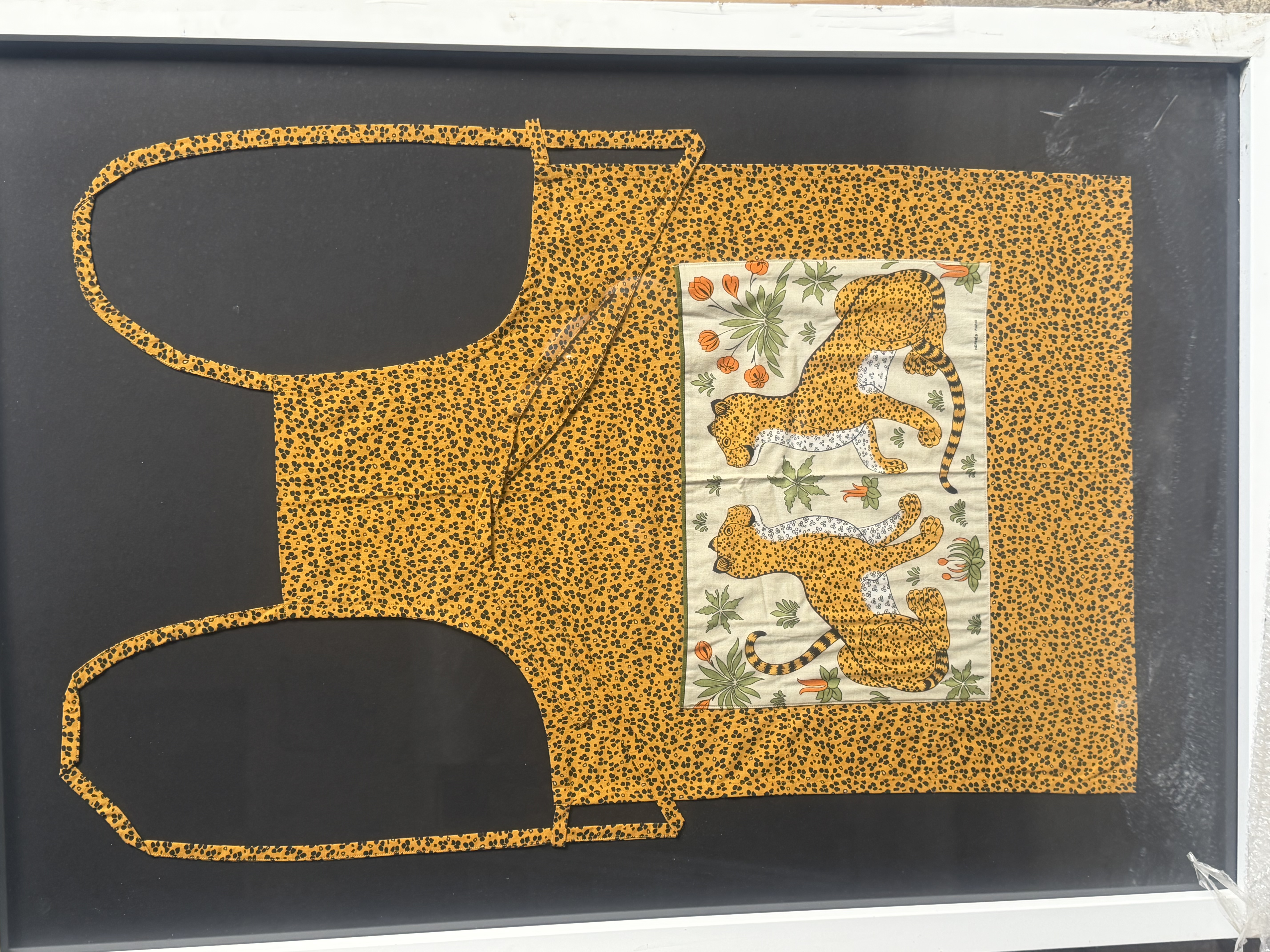 Vêtement textile jaune tacheté orné d’un panneau représentant deux félins et des fleurs